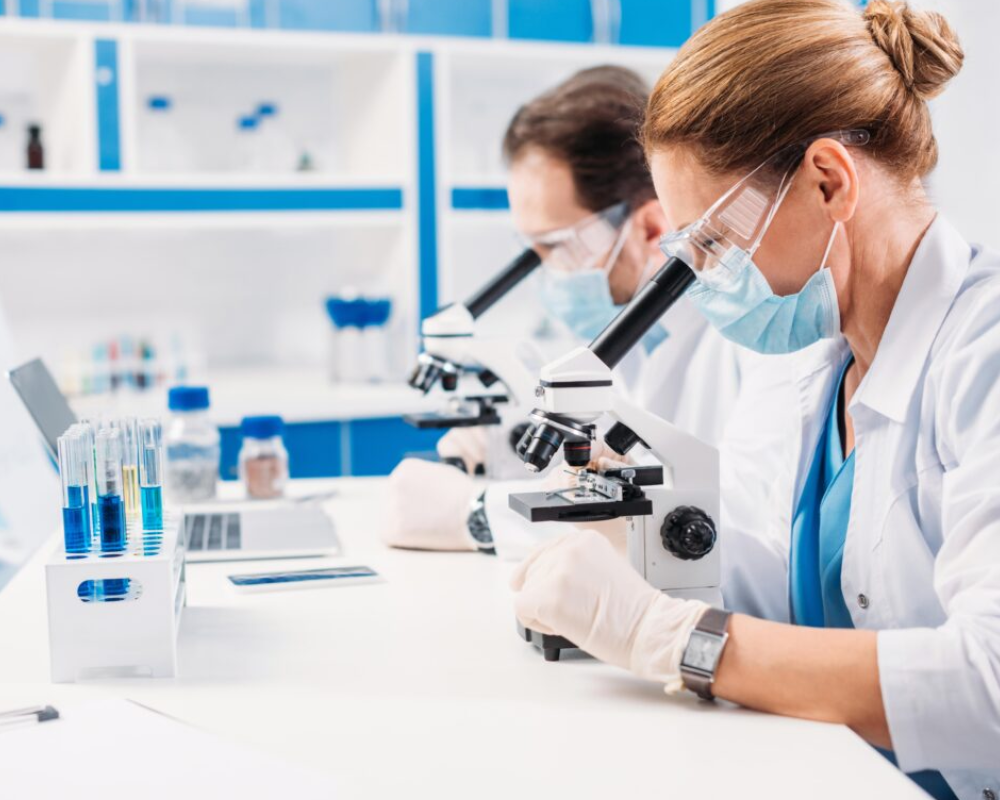 Científicos usando microscopios en laboratorio moderno