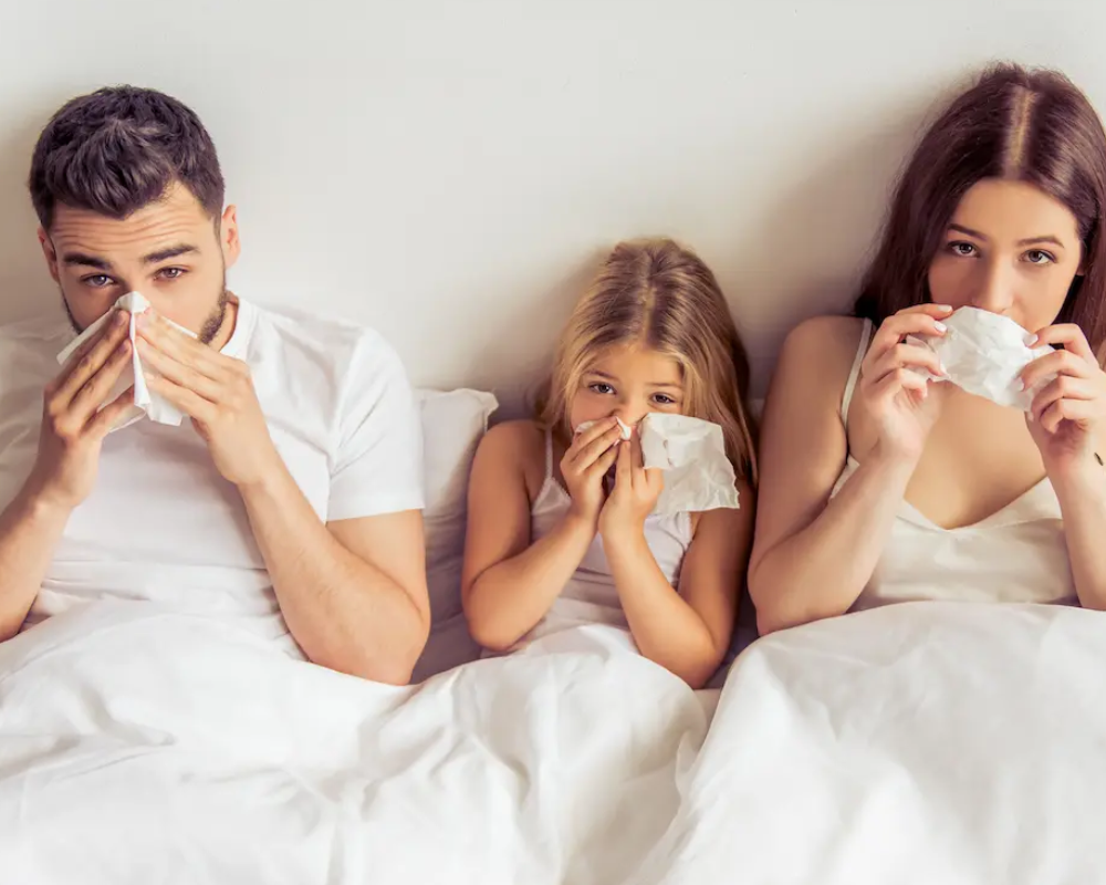 Familia resfriada en la cama