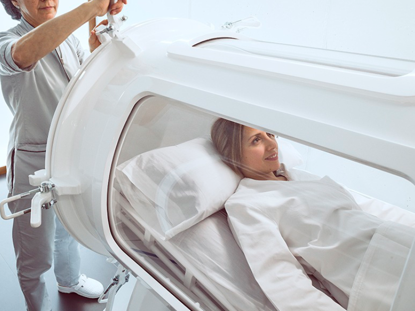 Mujer en cámara hiperbárica transparente