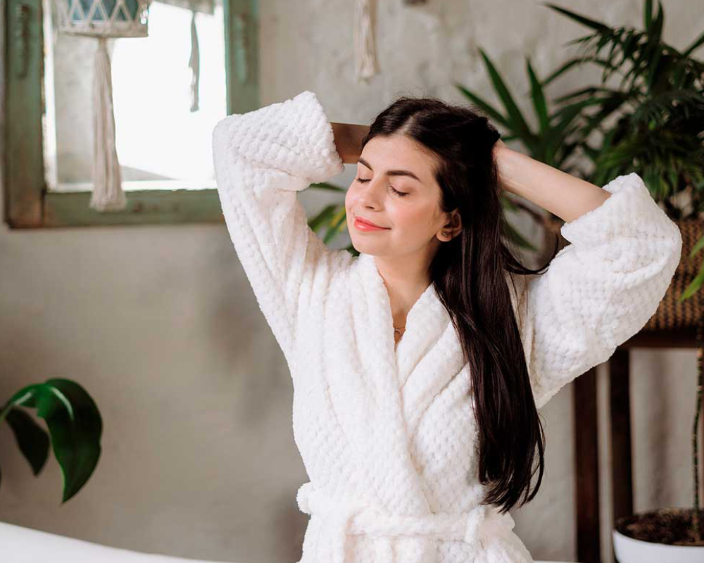 Mujer relajándose en bata blanca